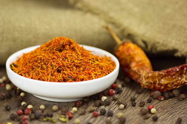 Saffron in saucer with pepper and chili — Stock Photo, Image