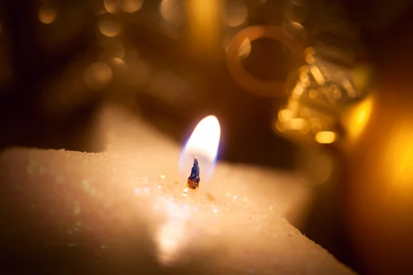 Christmas star-shaped candle with glitter and baubles — Stock Photo, Image