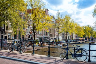 Amsterdam, Hollanda - 24 Eylül 2021: Park halindeki bisikletleri, evleri ve köprüsü ile Amsterdam 'ın sonbahar manzarası. Amsterdam, Hollanda, Hollanda, Avrupa.