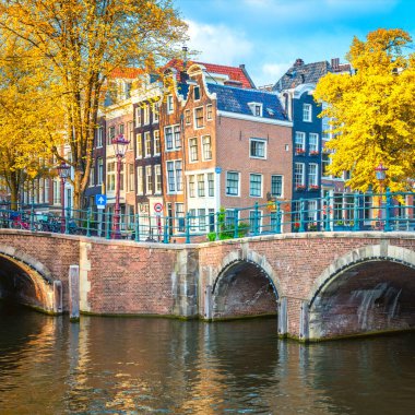 Amsterdam 'ın eski kalbinin ünlü manzarası - eski eğimli evler, köprüler ve kanallar. Amsterdam 'da sonbahar günü. Amsterdam, Hollanda, Avrupa