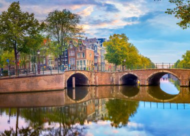 Amsterdam Şehir Merkezi. Gün doğumunda güzel bir gökyüzü, eski evler, kanallar ve köprüler. Sudaki sakin yansımalar. Amsterdam 'ın kalbi. Amsterdam, Hollanda, Hollanda, Avrupa 
