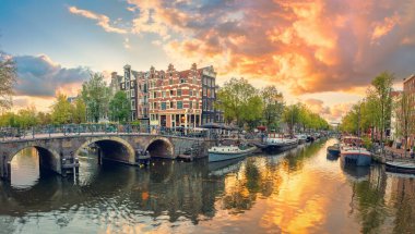 Amsterdam mı? Amsterdam şehir merkezinin panoramik manzarası. Amsterdam 'ın geleneksel evleri ve köprüleri. Renkli bir gün batımı zamanı. Klasik tonlu. Tarihi bir şehre Avrupa seyahati. Avrupa, Hollanda, Hollanda, Amsterdam.