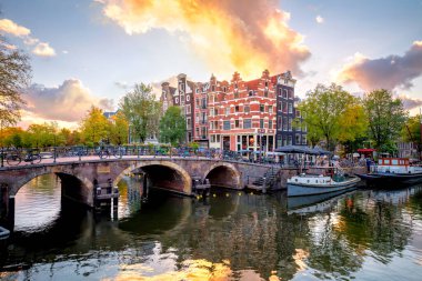 Amsterdam mı? Hollanda. Amsterdam şehir merkezi. Amsterdam 'ın geleneksel evleri ve köprüleri. Renkli bir gün batımı zamanı. Tarihi bir şehre Avrupa seyahati. Avrupa, Hollanda, Hollanda, Amsterdam.