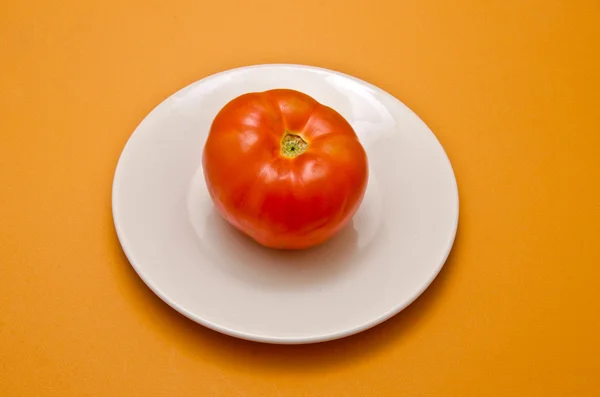 Белая тарелка с помидорами — стоковое фото