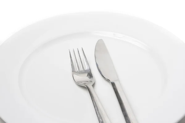 Fourchette et couteau sur une assiette blanche — Photo