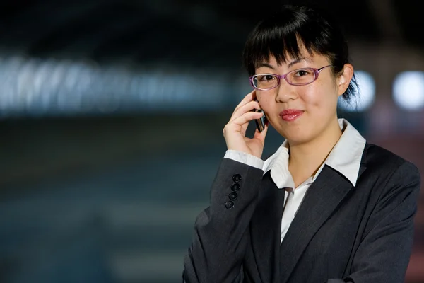 Aziatische zakenvrouw met mobiele telefoon — Stockfoto