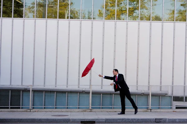 Hombre de negocios aferrándose a su paraguas —  Fotos de Stock