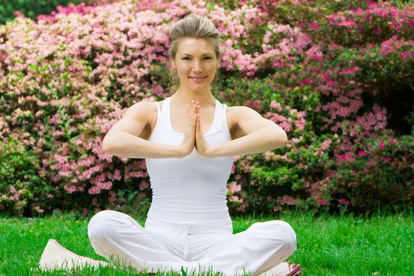 Blondynka w parku robienie yoga — Zdjęcie stockowe