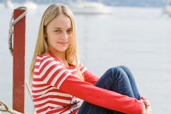 Гарненька білявка дівчина розслабляється біля води Ліцензійні Стокові Фото