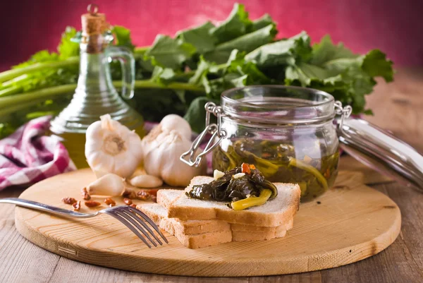 Sliced bread with turnip tops under oil. — Stock Photo, Image