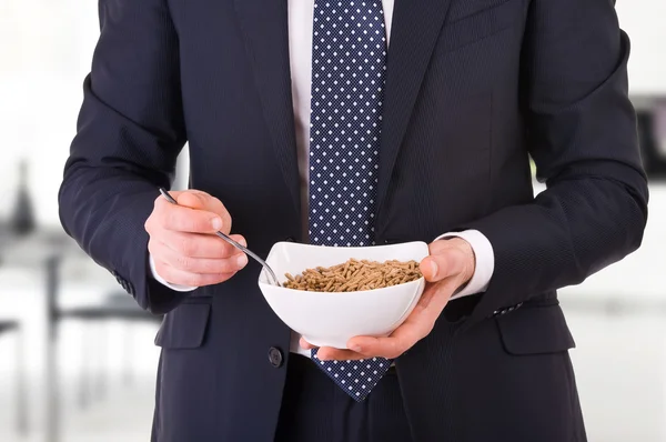 Businessman having breakfast with cereal bowl. — Stock Photo, Image