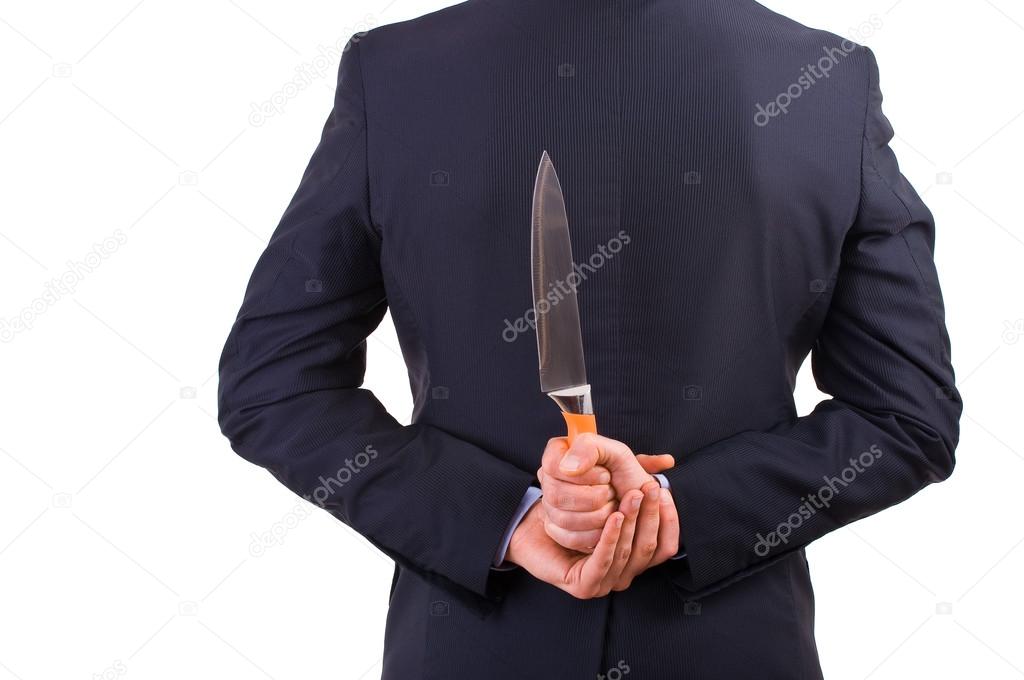 Businessman holding knife behind his back.