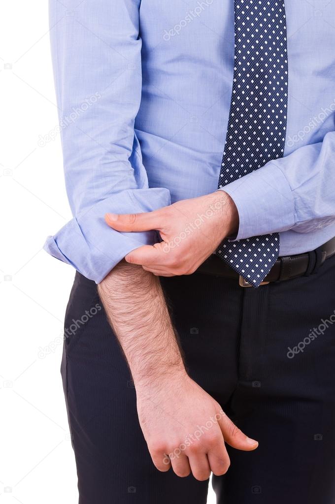 Businessman rolling up his shirt sleeves.