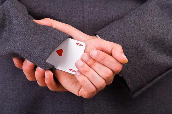 Empresario sosteniendo cartas a sus espaldas . — Foto de Stock