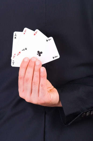 Empresario sosteniendo cartas a sus espaldas . — Foto de Stock