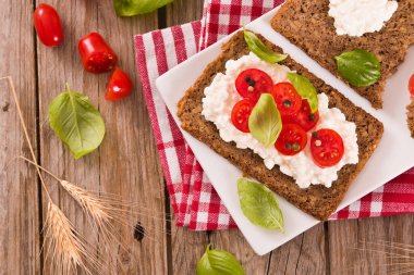 Çavdar ekmeği, süzme peynir, fesleğen ve domates..