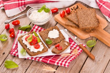 Çavdar ekmeği, süzme peynir, fesleğen ve domates..