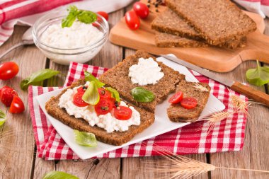 Çavdar ekmeği, süzme peynir, fesleğen ve domates..
