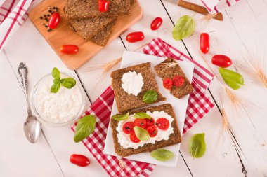 Çavdar ekmeği, süzme peynir, fesleğen ve domates..