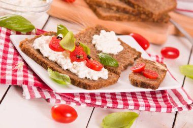 Çavdar ekmeği, süzme peynir, fesleğen ve domates..