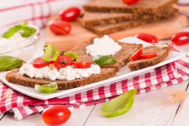 Çavdar ekmeği, süzme peynir, fesleğen ve domates..