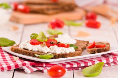 Çavdar ekmeği, süzme peynir, fesleğen ve domates..