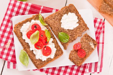 Çavdar ekmeği, süzme peynir, fesleğen ve domates..