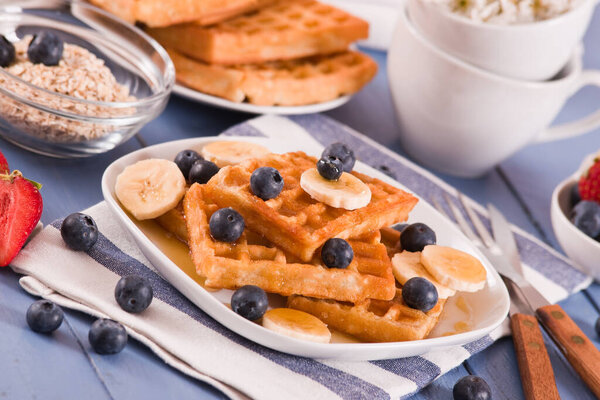 Waffles with blueberries, bananas and honey.