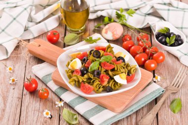 Fusilli pasta with cherry tomatoes, eggs and black olives.