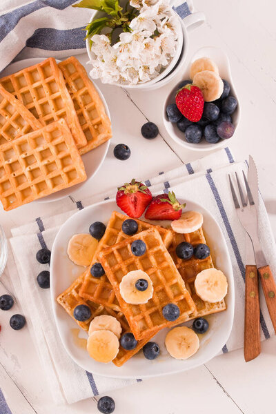 Waffles with blueberries, bananas and honey.