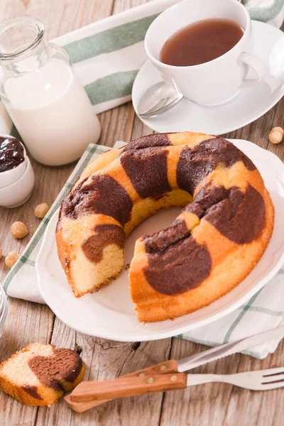 白い皿の上にヘーゼルナッツと大理石のリングケーキ — ストック写真