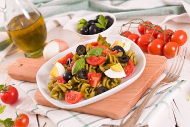 Fusilli pasta with cherry tomatoes, eggs and black olives.