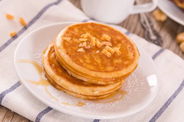 Beyaz tabakta taneli ballı krep..