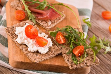 Susamlı kızarmış çavdar ekmeği, jambon ve süzme peynir..