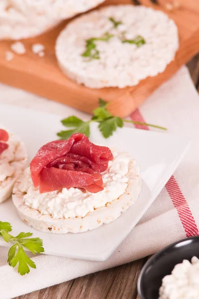 Rice cakes with milk flakes and cold beef.