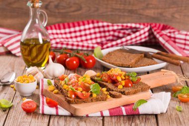 Tatlı mısır, fesleğen ve domatesli çavdar ekmeği..