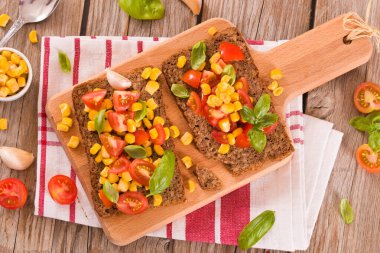 Tatlı mısır, fesleğen ve domatesli çavdar ekmeği..