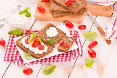 Çavdar ekmeği, süzme peynir, fesleğen ve domates..