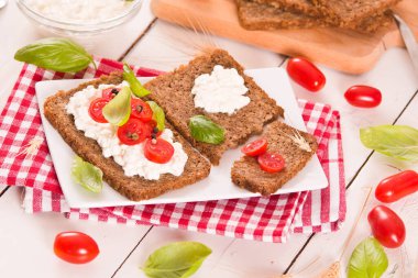 Çavdar ekmeği, süzme peynir, fesleğen ve domates..