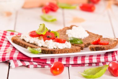 Çavdar ekmeği, süzme peynir, fesleğen ve domates..