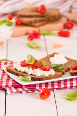 Çavdar ekmeği, süzme peynir, fesleğen ve domates..
