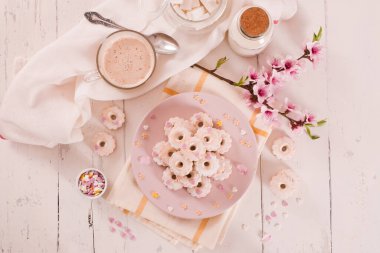 Canestrelli bisküvileri. Beyaz tabakta krema şekeri.. 