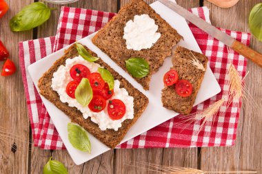 Çavdar ekmeği, süzme peynir, fesleğen ve domates..