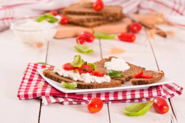 Çavdar ekmeği, süzme peynir, fesleğen ve domates..