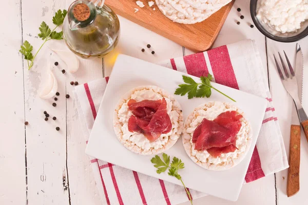 Rice cakes with milk flakes and cold beef.