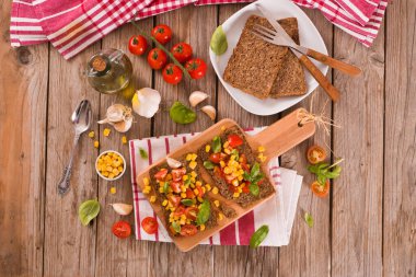 Tatlı mısır, fesleğen ve domatesli çavdar ekmeği..