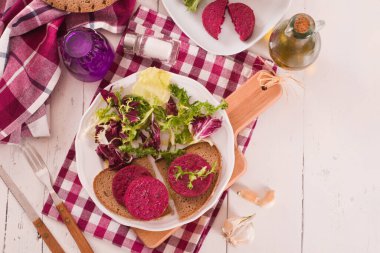 Beetroot vejetaryen burgeri beyaz tabakta.