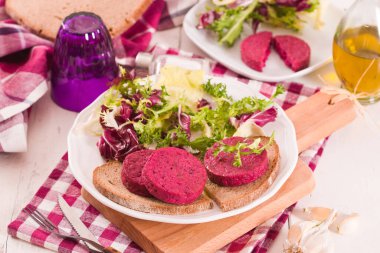 Beetroot vejetaryen burgeri beyaz tabakta.