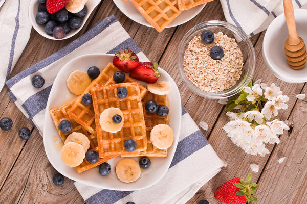 Waffles with blueberries, bananas and honey.