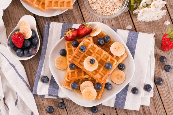 Waffles with blueberries, bananas and honey.